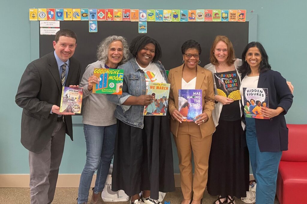 NCFL's President and CEO Dr. Felicia C. Smith and Director, North Carolina David Sisk stand with Book Harvest staff. They are each holding a book and smiling.