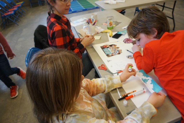 Two children work on a collage with their mother